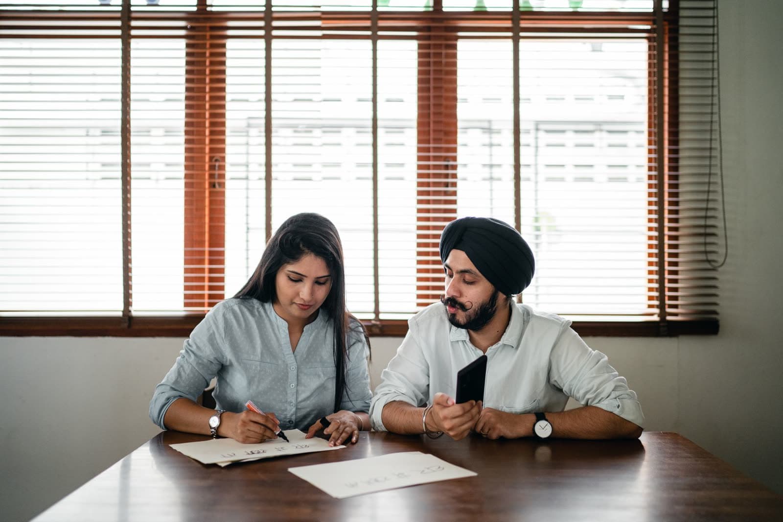 A couple sitting at a table and going through papers together
